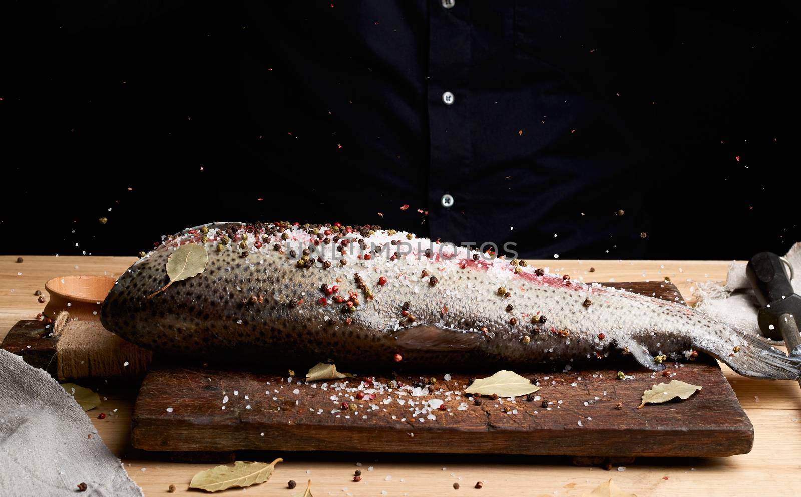 headless salmon fillet on a wooden board sprinkled with large wh by ndanko