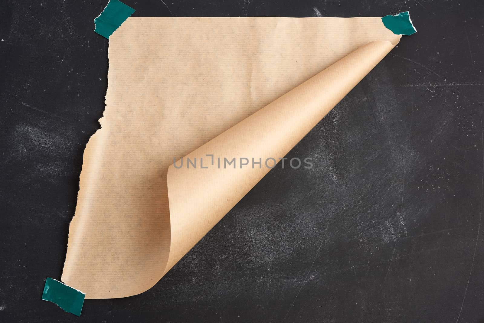 brown torn piece of paper is glued with green velcro on a black board, bottom corner is wrapped, place for an inscription