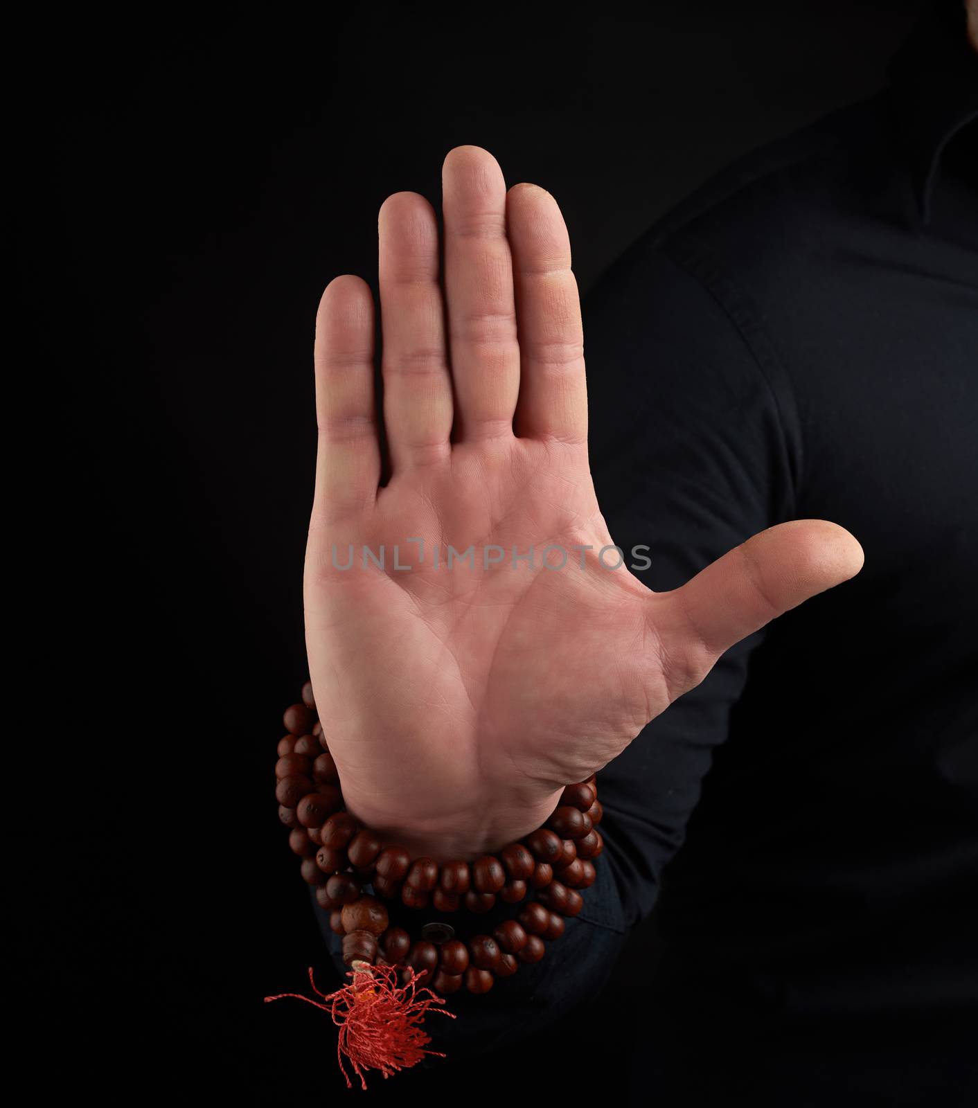 hand of an adult male shows mudra on a dark background by ndanko