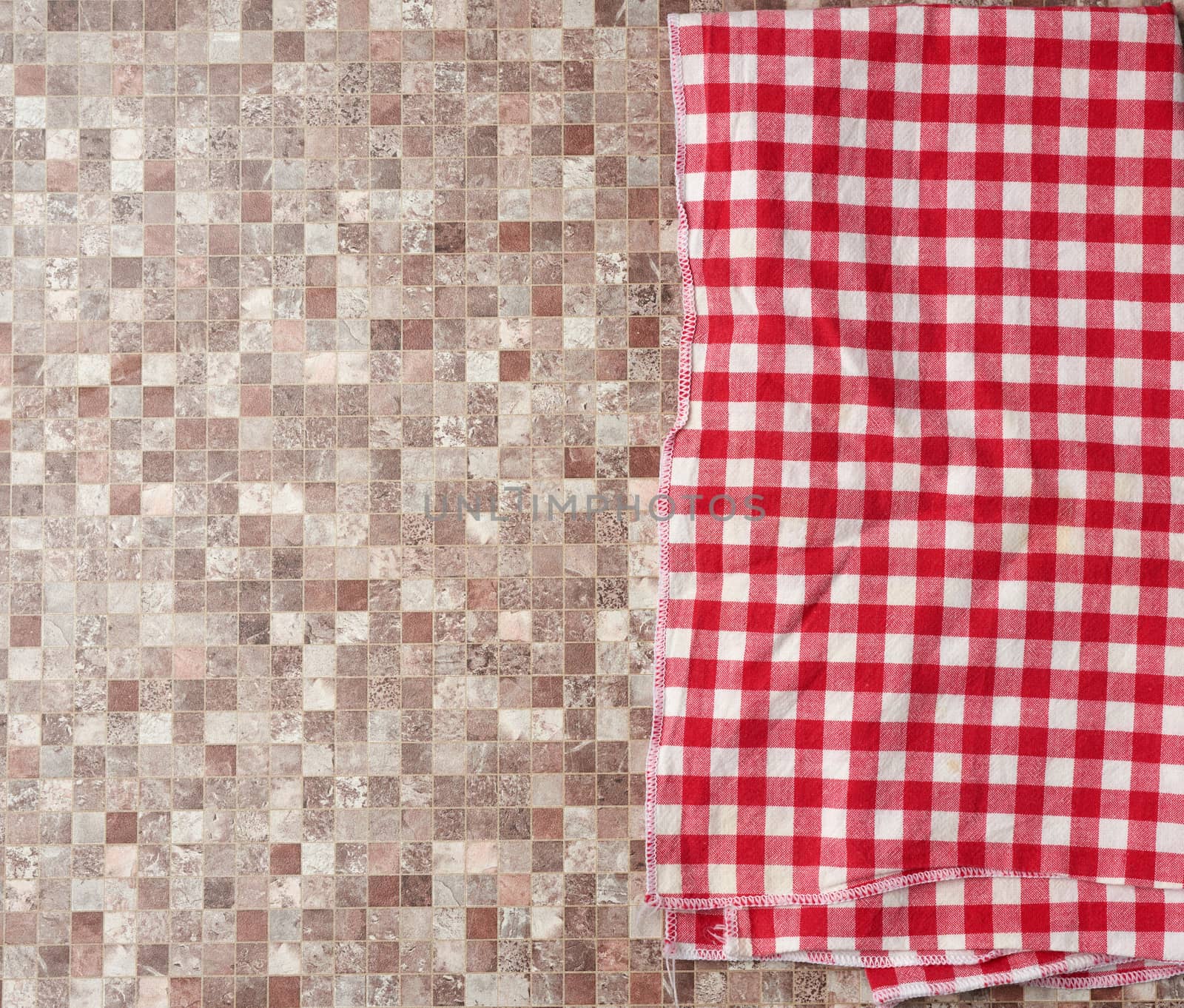 red checked cotton kitchen towel on a brown kitchen surface, top view, copy space
