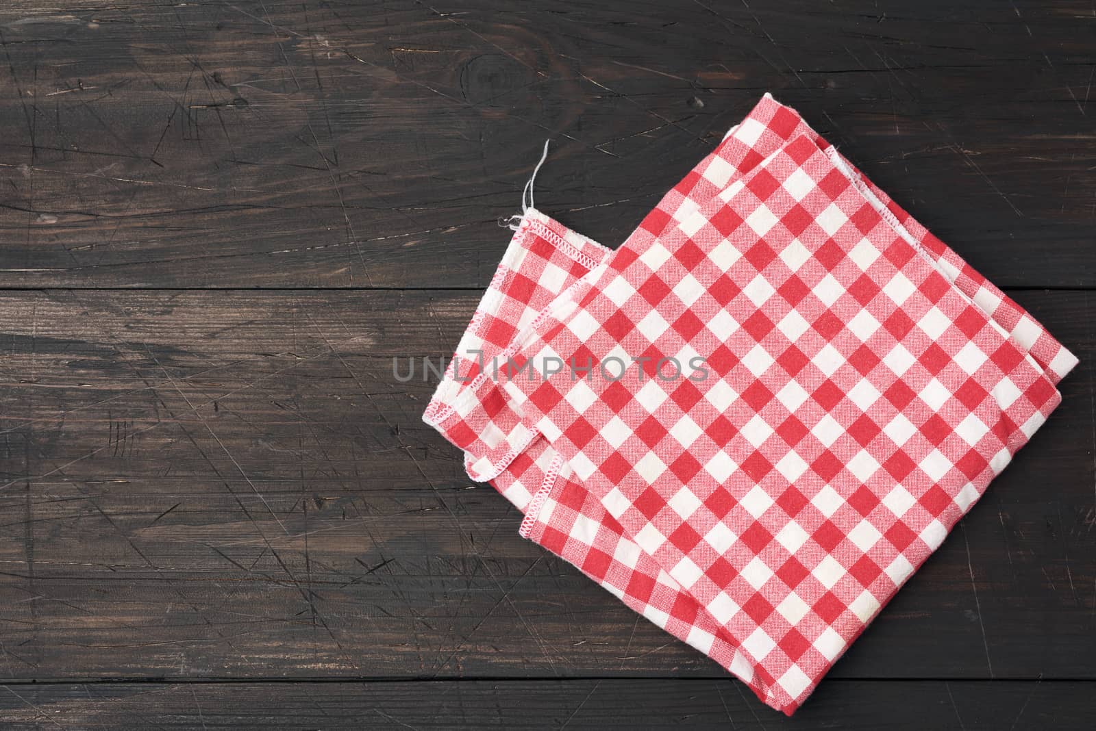 red-white textile kitchen towel on a brown wooden background fro by ndanko