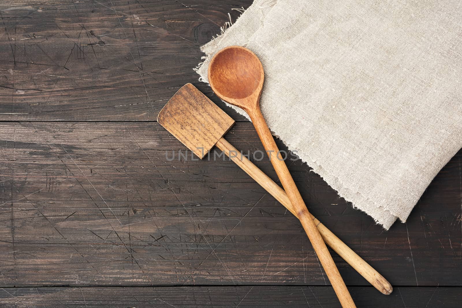 empty wooden spoon and spatula on a brown wooden background  by ndanko