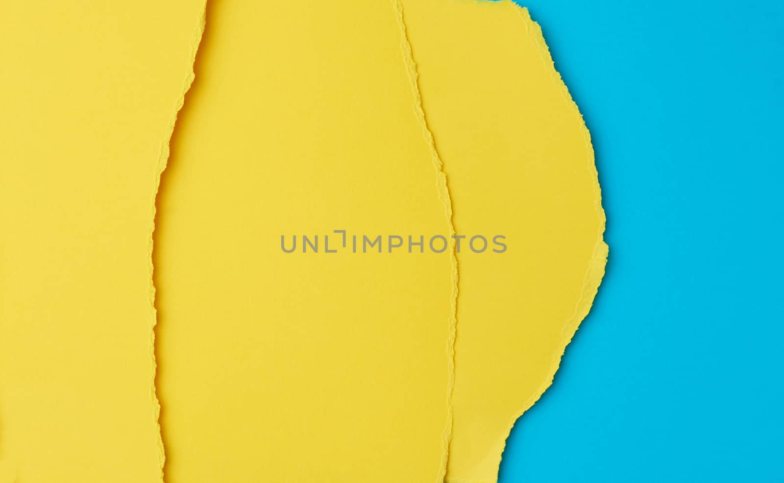 background of layered yellow torn paper with a shadow on a blue  by ndanko