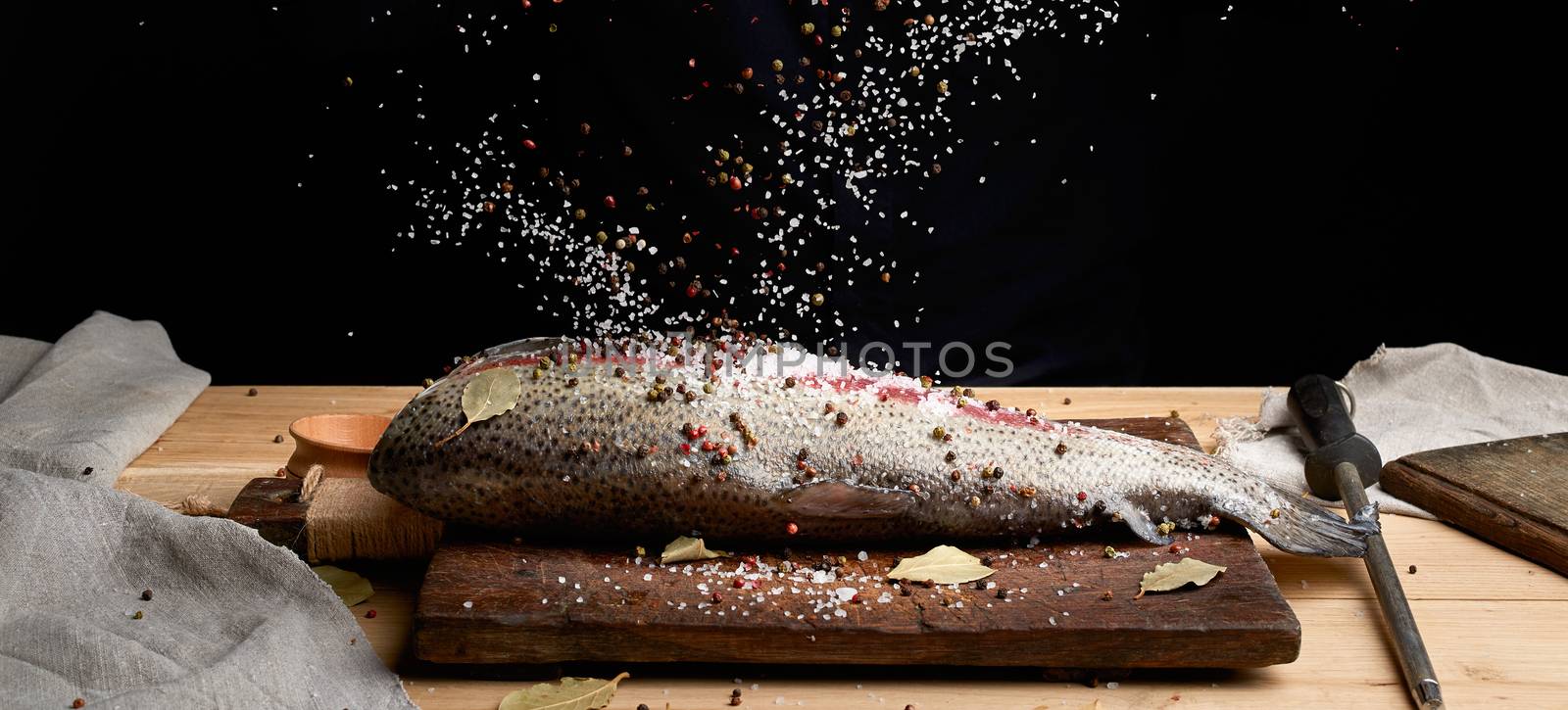 headless salmon fillet on a wooden board sprinkled with large wh by ndanko