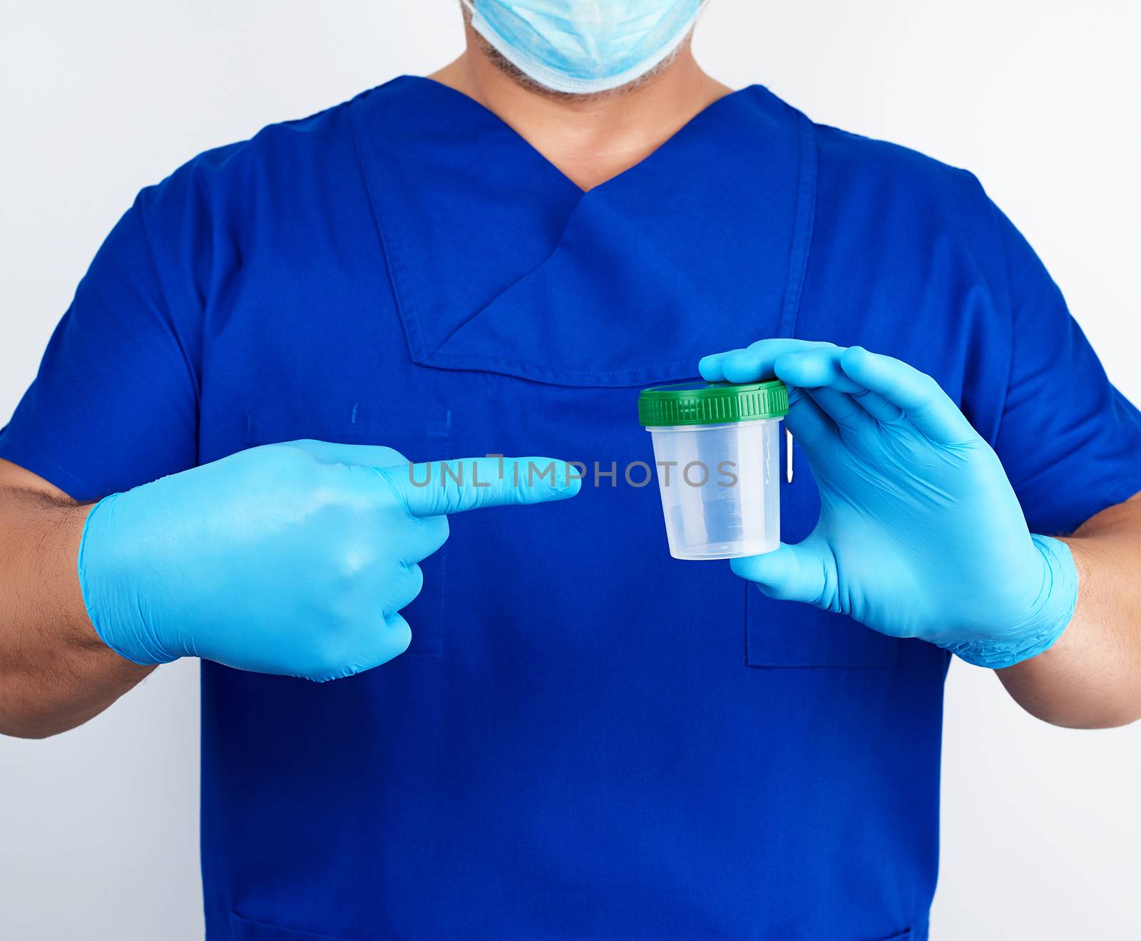 doctor in blue uniform and latex gloves is holding an empty plastic container for taking urine samples, concept of timely diagnosis