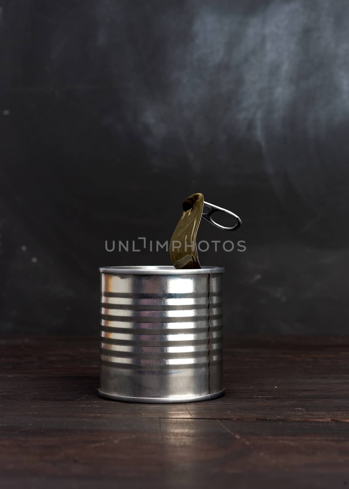 open hard iron can for food preservation on a wooden background, copy space