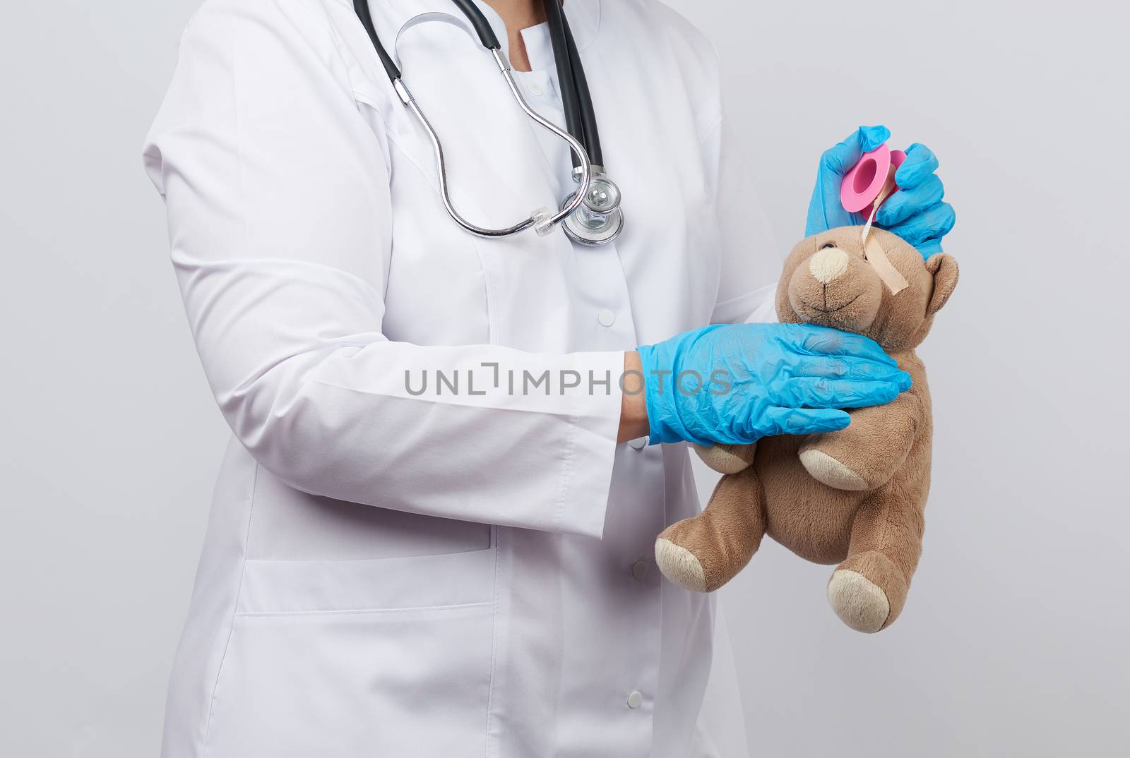 female doctor in a white coat and blue latex gloves holds a brow by ndanko