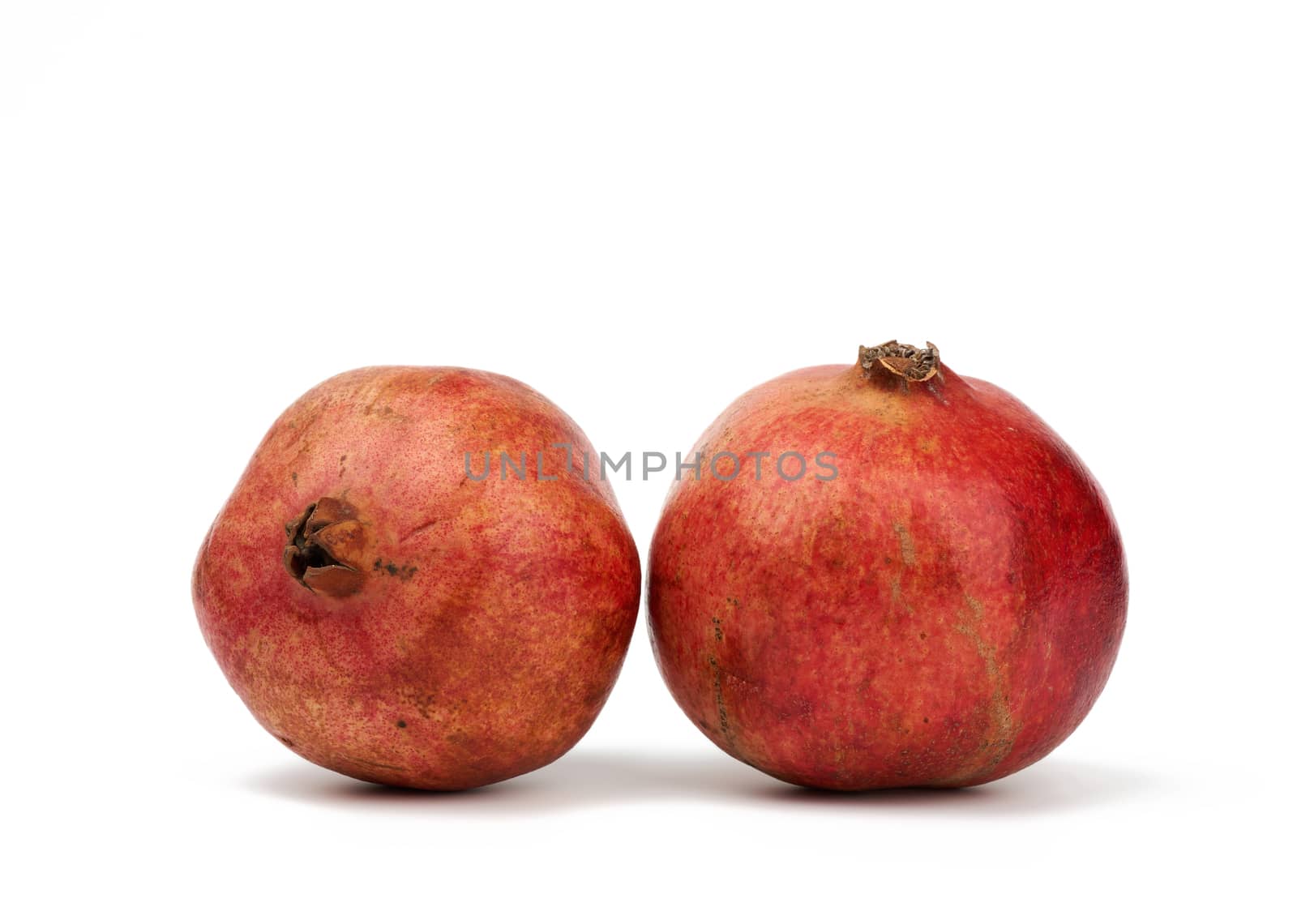round red ripe pomegranate fruit in peel isolated on a white bac by ndanko