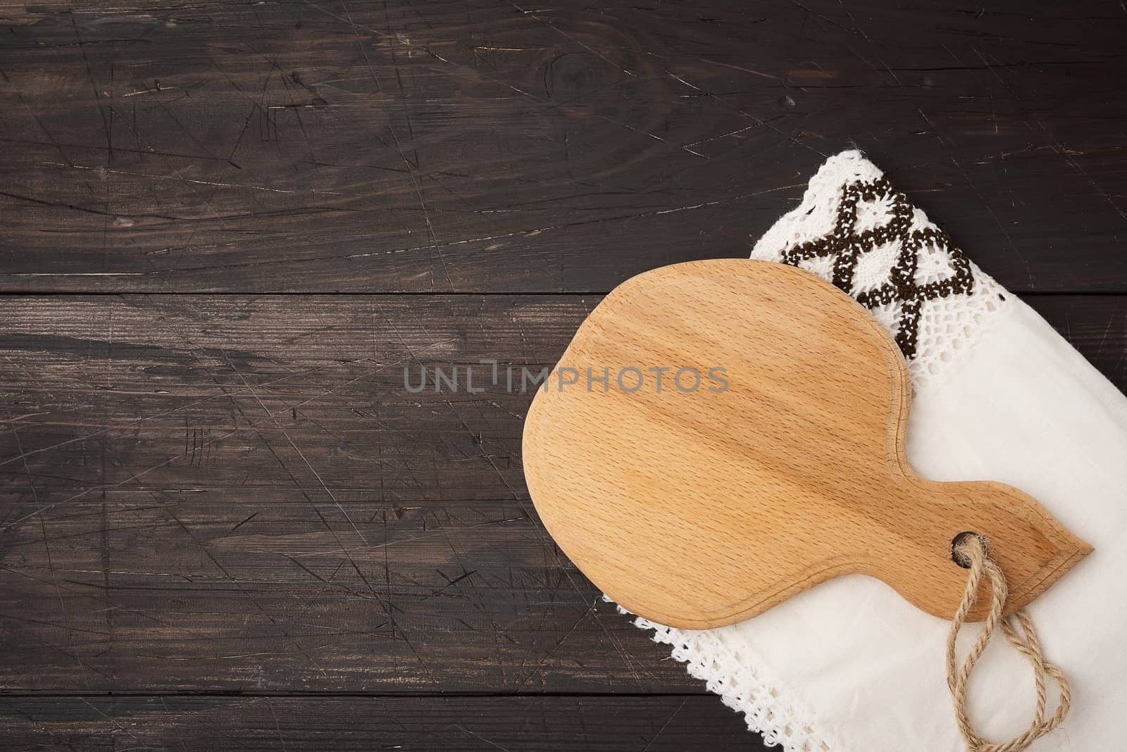 empty brown kitchen cutting board with handle, top view, copy space