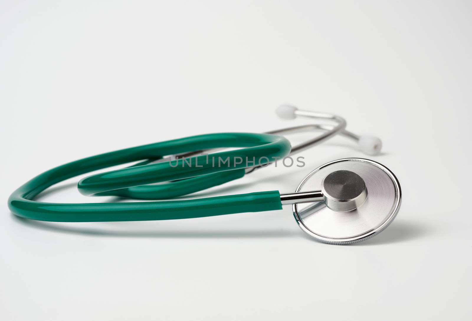 green medical stethoscope on white background, medical item for measurement