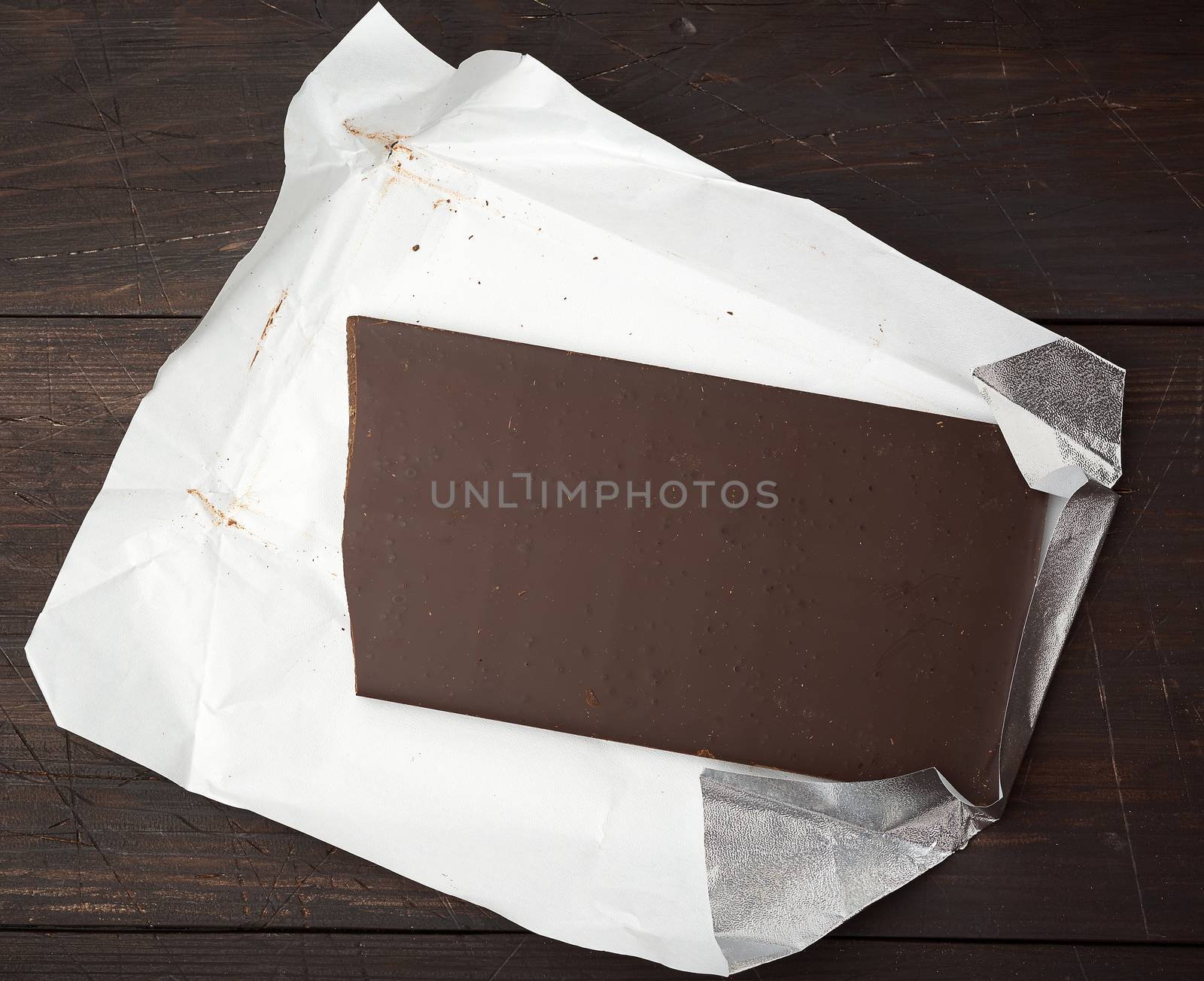 bar of black chocolate on white paper by ndanko