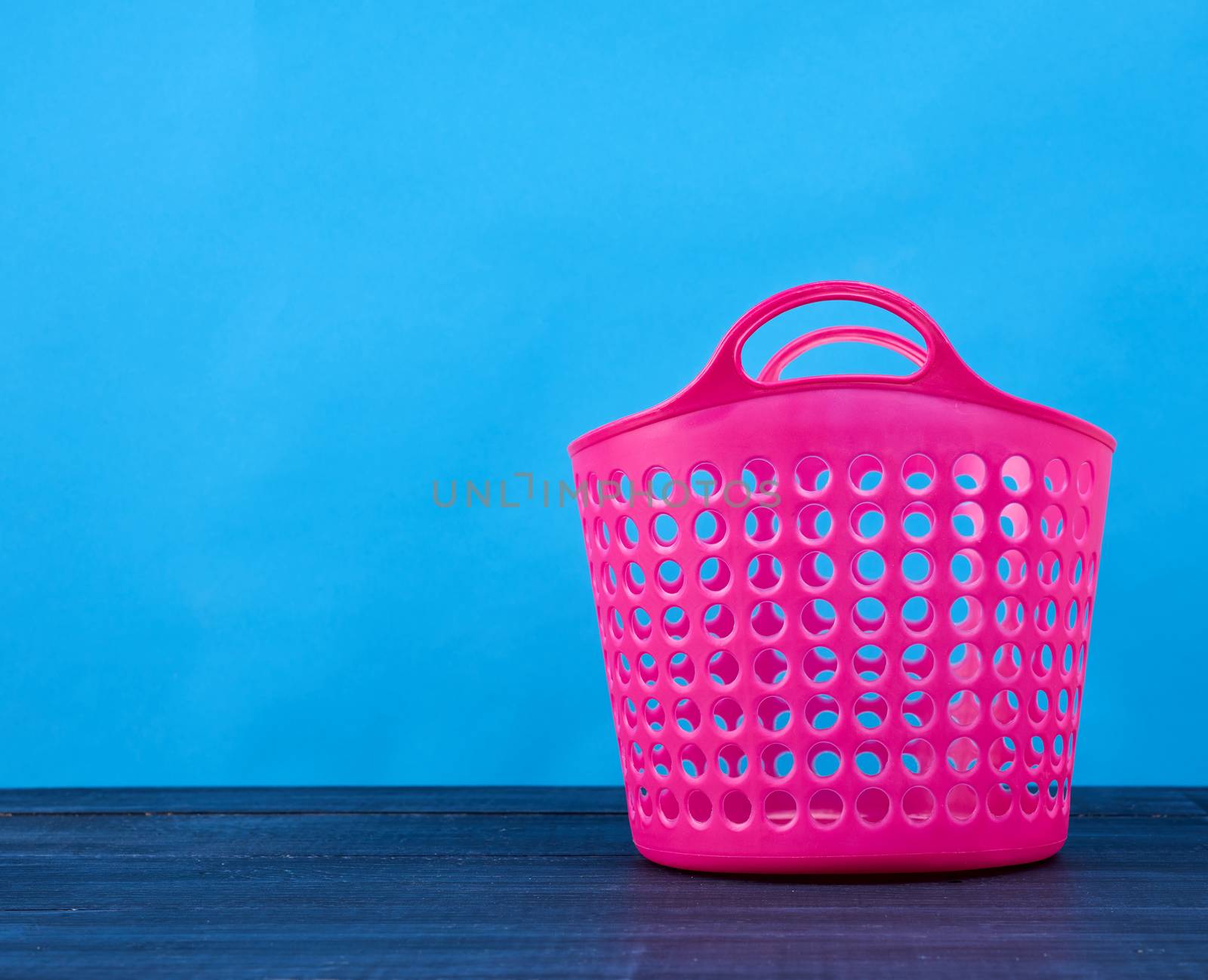 plastic pink basket in the hole for clean and dirty linen by ndanko