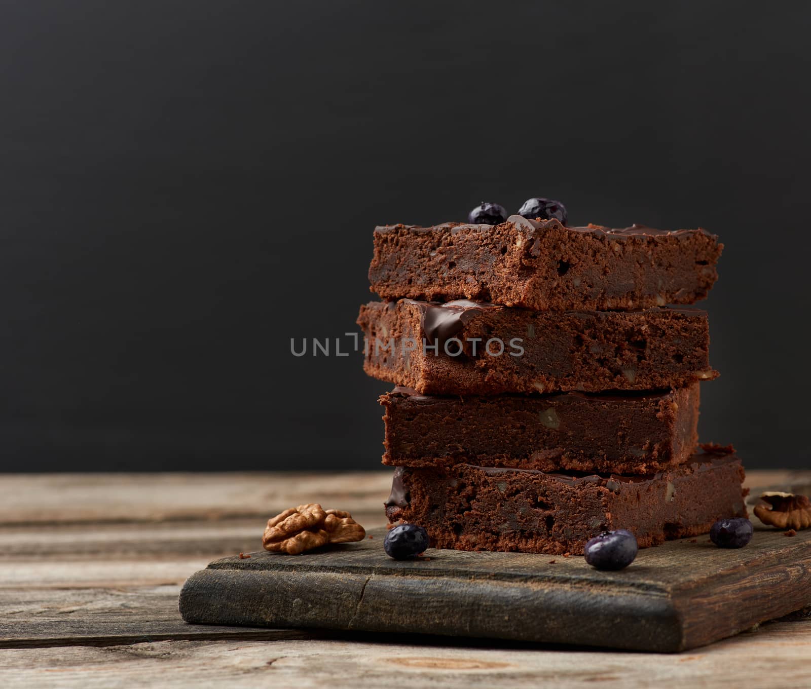 stack of square baked slices of brownie chocolate cake with waln by ndanko