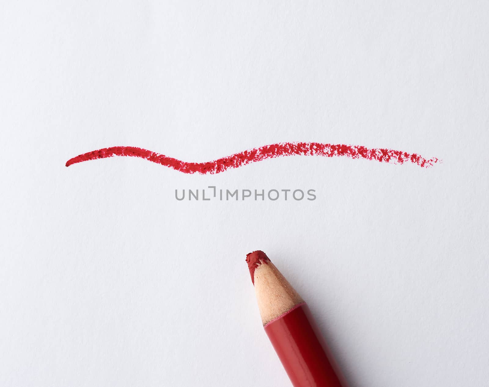 wooden red cosmetic lip liner and sample on a white background, close up