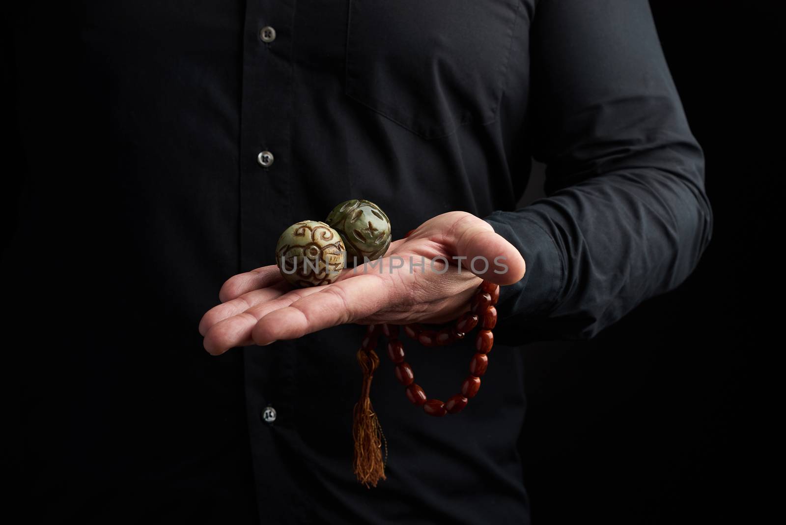 adult man in black clothes holds in his hands a magic ball, object for religious rituals, meditations and alternative medicine