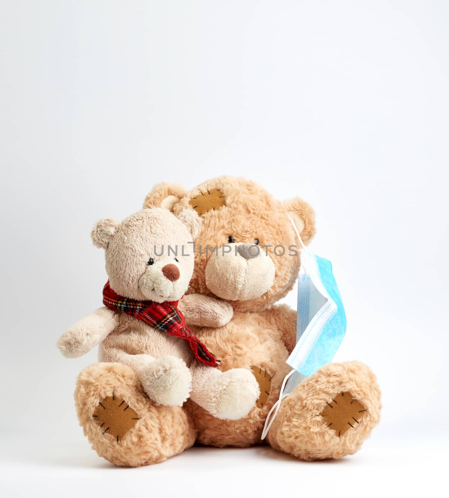 big teddy bear are sitting in blue medical masks on a blue background, concept of protection from respiratory disease, virus, and individual respiratory protection