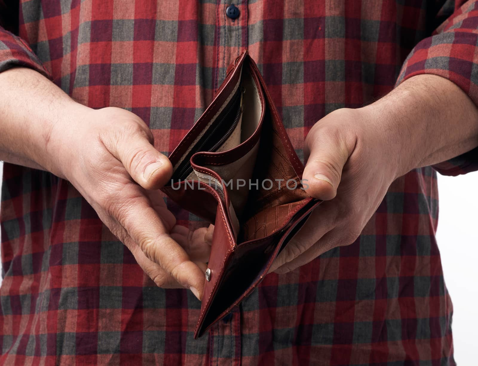 man in a red plaid shirt holds an empty leather brown wallet, concept of poverty and economic crisis