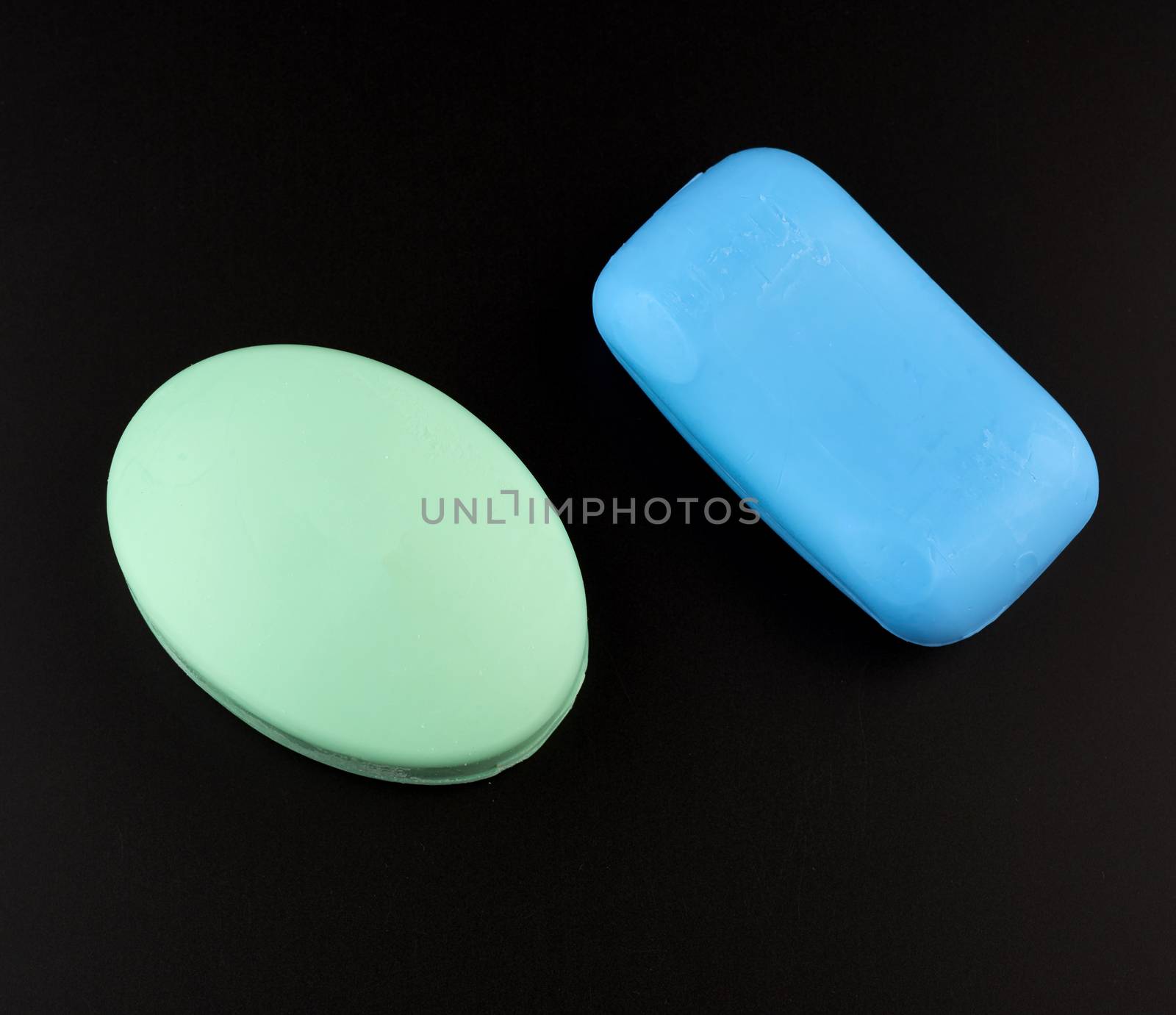 blue and green soaps on a black background, top view