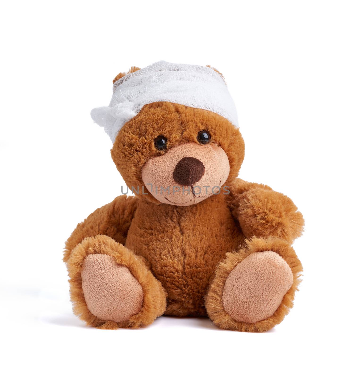brown teddy bear with a bandaged head in a white medical bandage on a white background, concept of child trauma, headache