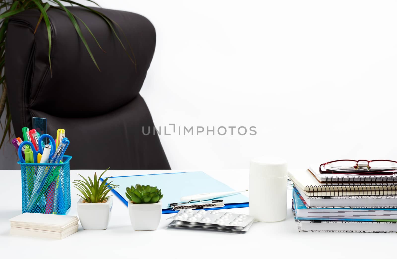 desk with stationery and empty brown leather chair, white background, doctor workplace