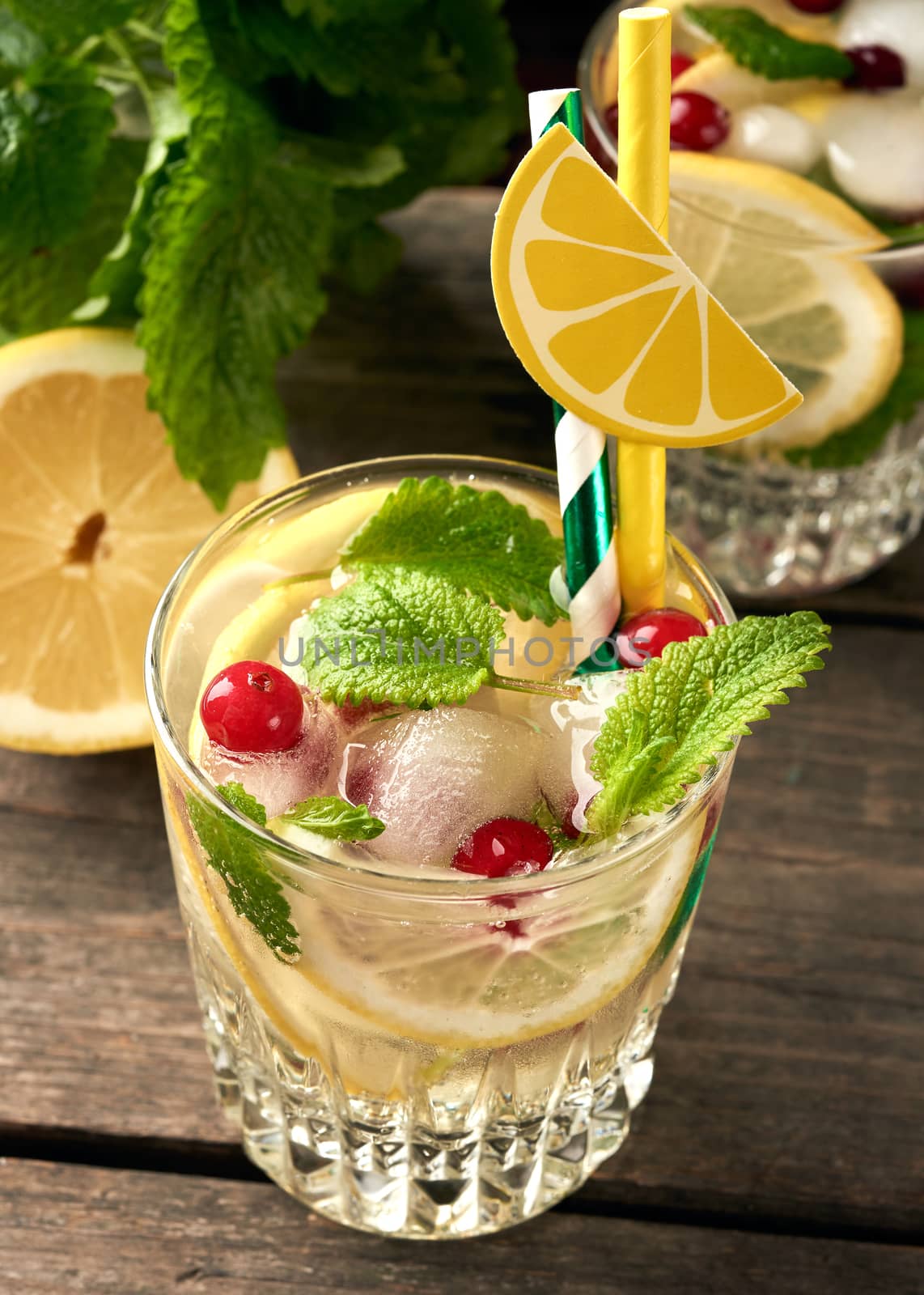 transparent glass with lemonade and pieces of ice, red berries, a refreshing summer drink , top view