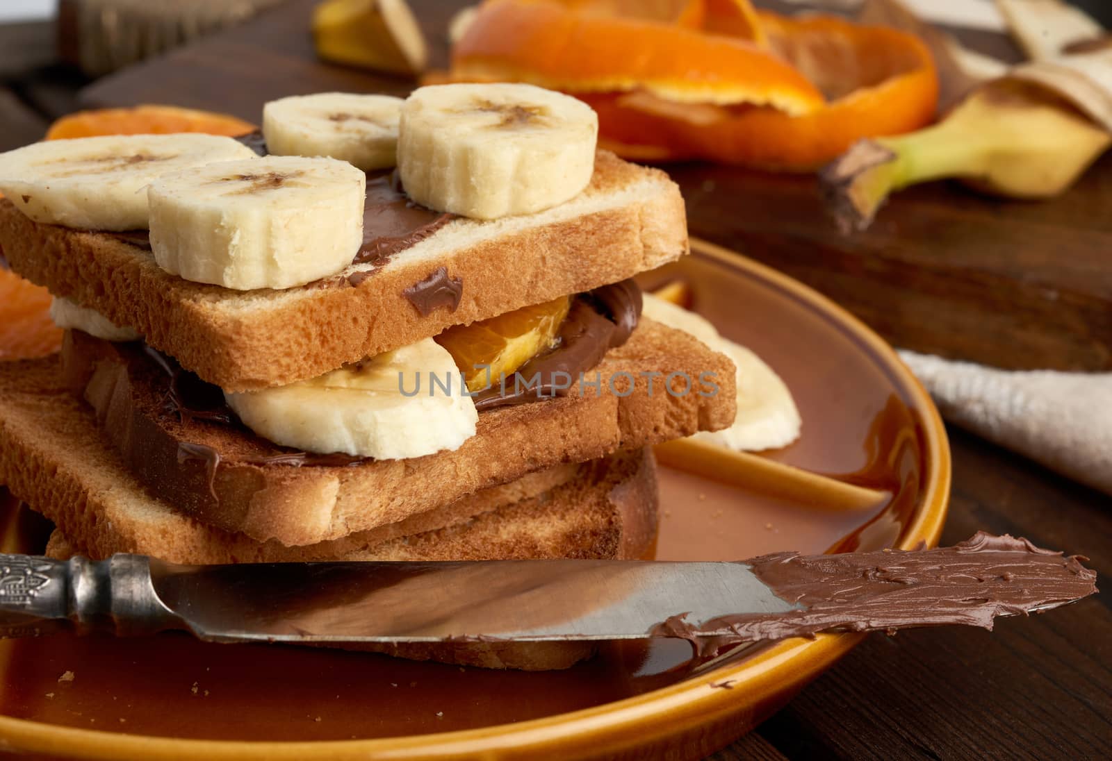 sandwiches with chocolate paste and banana slices on a plate, morning breakfast