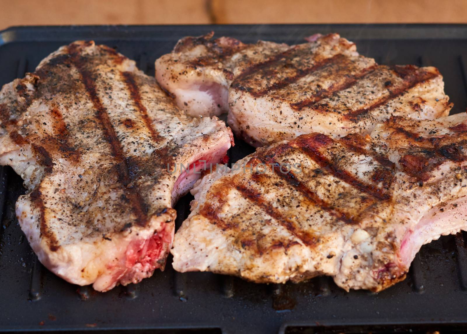 grilled pork tenderloin on the ribs, delicious food, spiced meat, close up