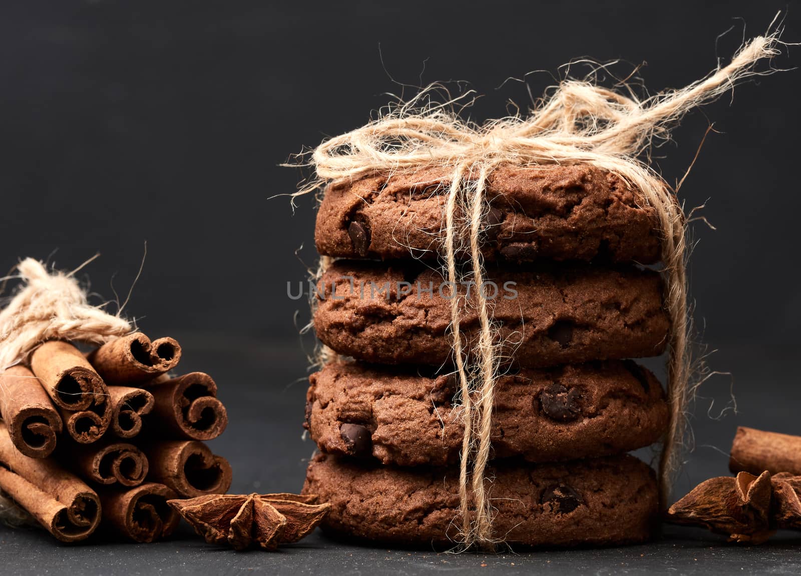 stack of round chocolate chip cookies tied with a rope on a black board, delicious dessert