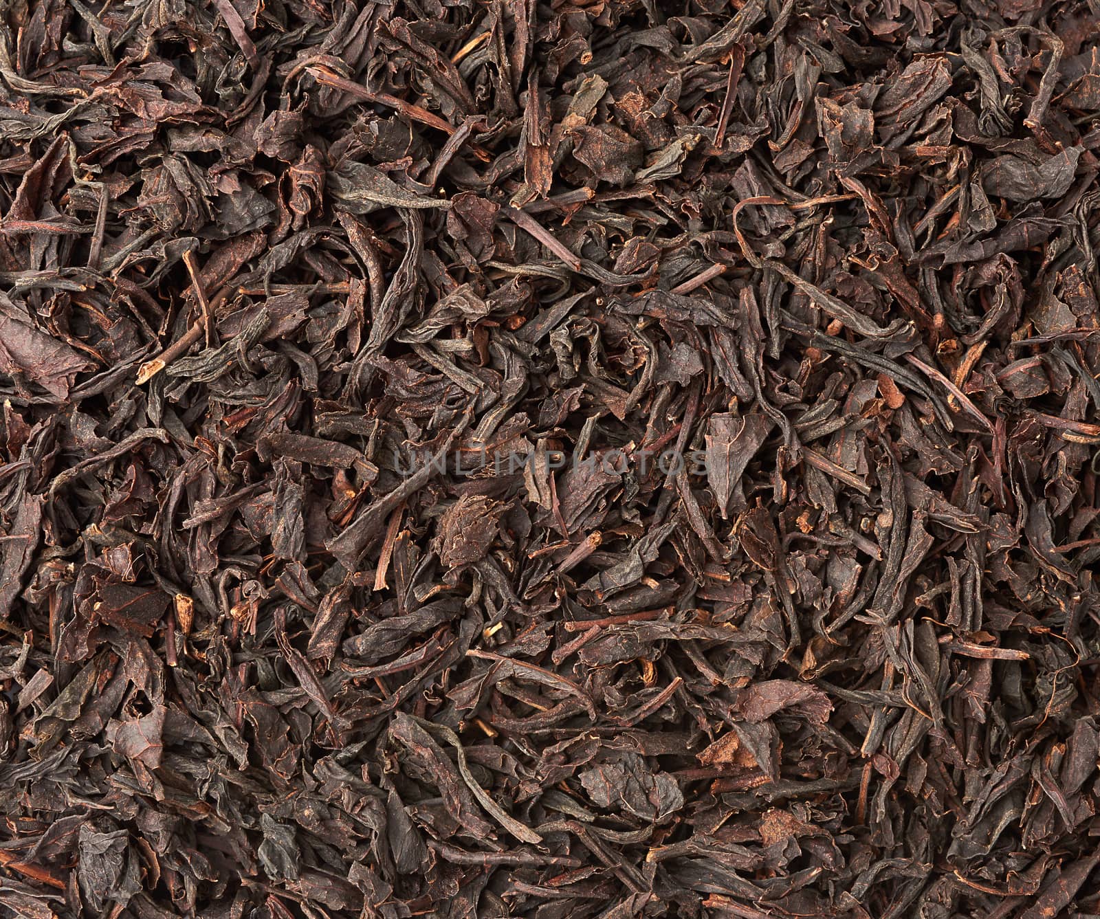 texture of dry black long leaf tea, top view, ingredients for a hot drink, close up