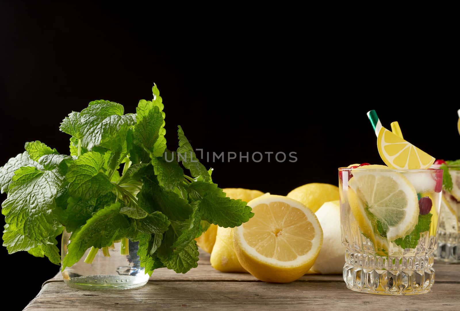 yellow ripe lemon and a bunch of fresh green mint on a wooden board, ingredients for lemonade