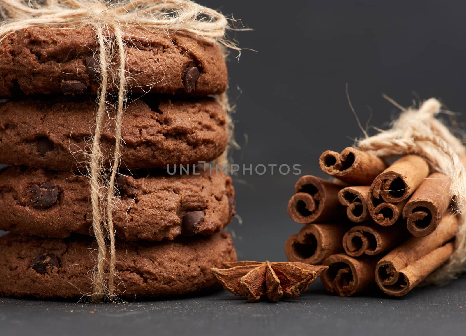 stack of round chocolate chip cookies tied with a rope on a black board, delicious dessert