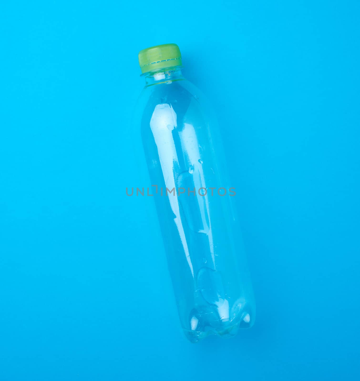 empty transparent plastic bottle on a blue background, top view