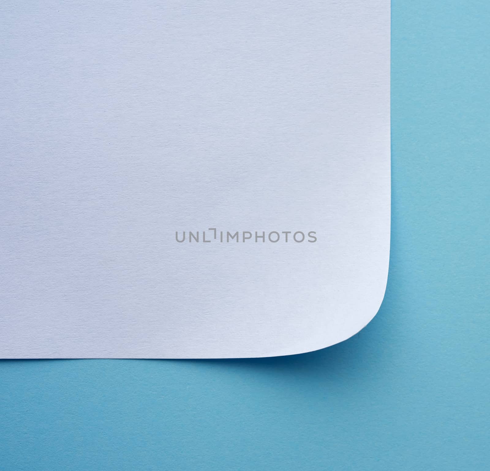 wrapped sheet of white paper on a blue background, macro, top view