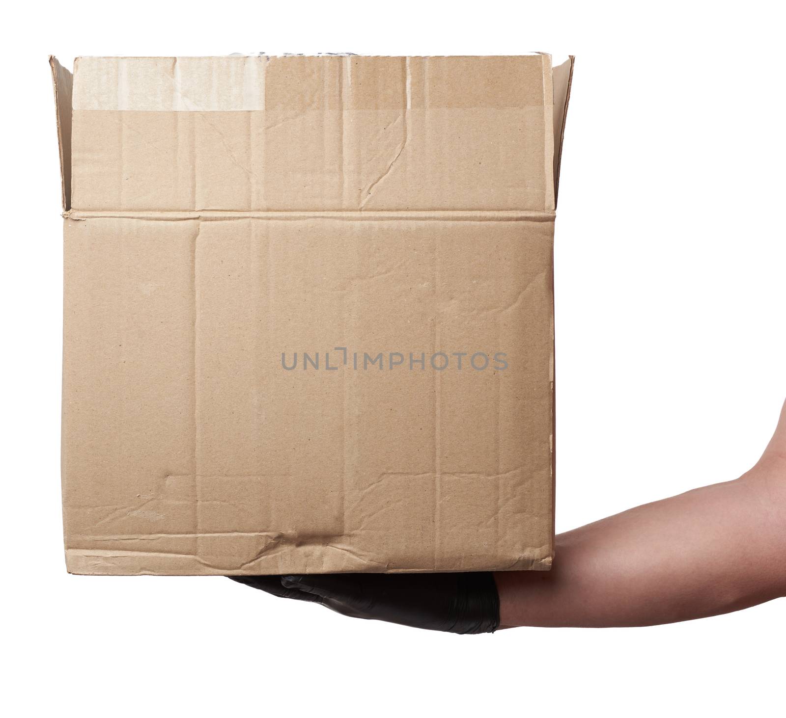 male hand in a black latex glove holds an open brown cardboard box on a white background, safe and contactless delivery of on-line orders during epidemics