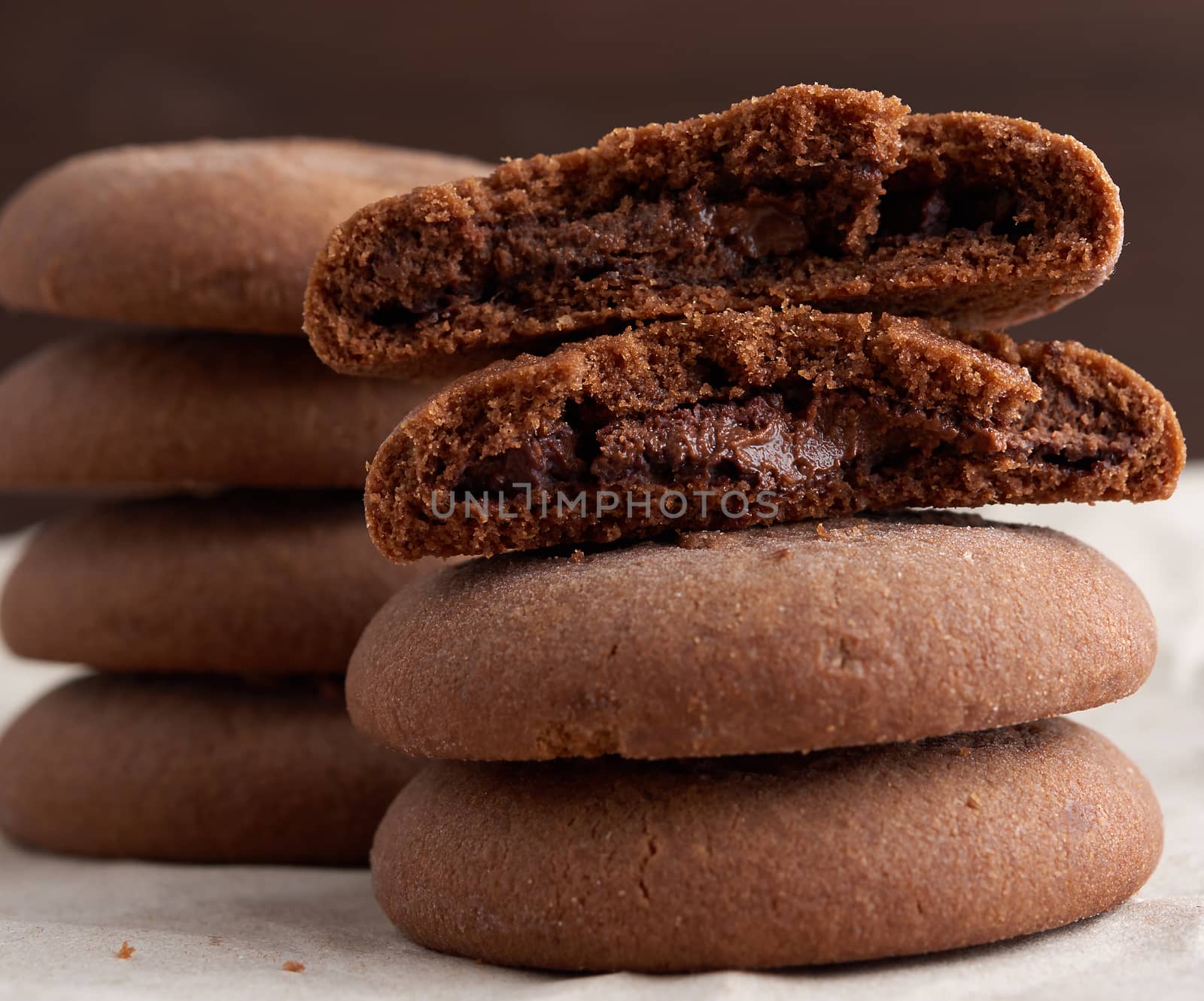 round chocolate chip cookies are stacked on a table, delicious dessert, close up