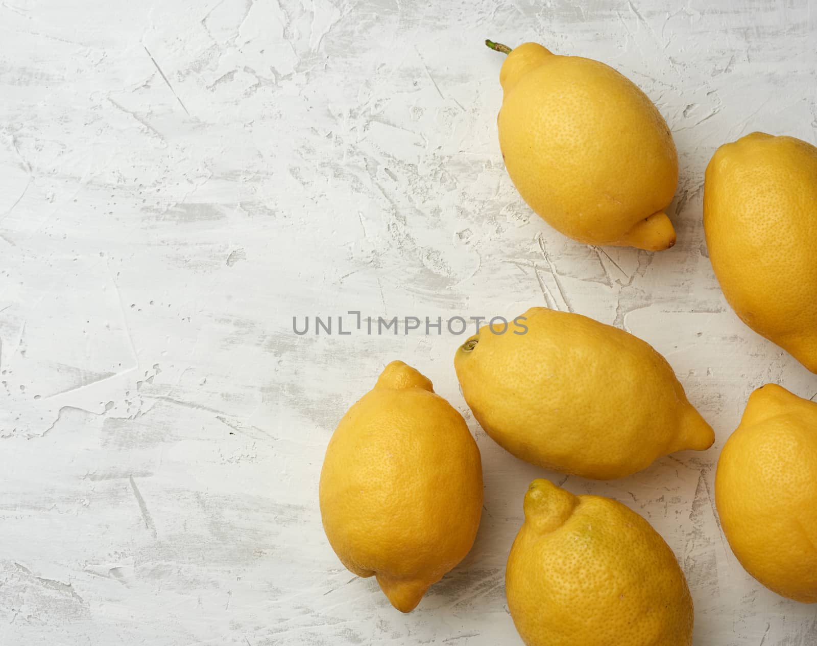 ripe yellow lemons on a gray table, ingredient for lemonade, top view, copy space
