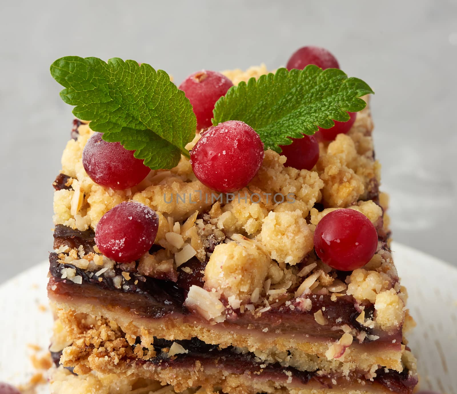 stack of square slices of baked crumble pie with blue plum, delicious dessert, close up