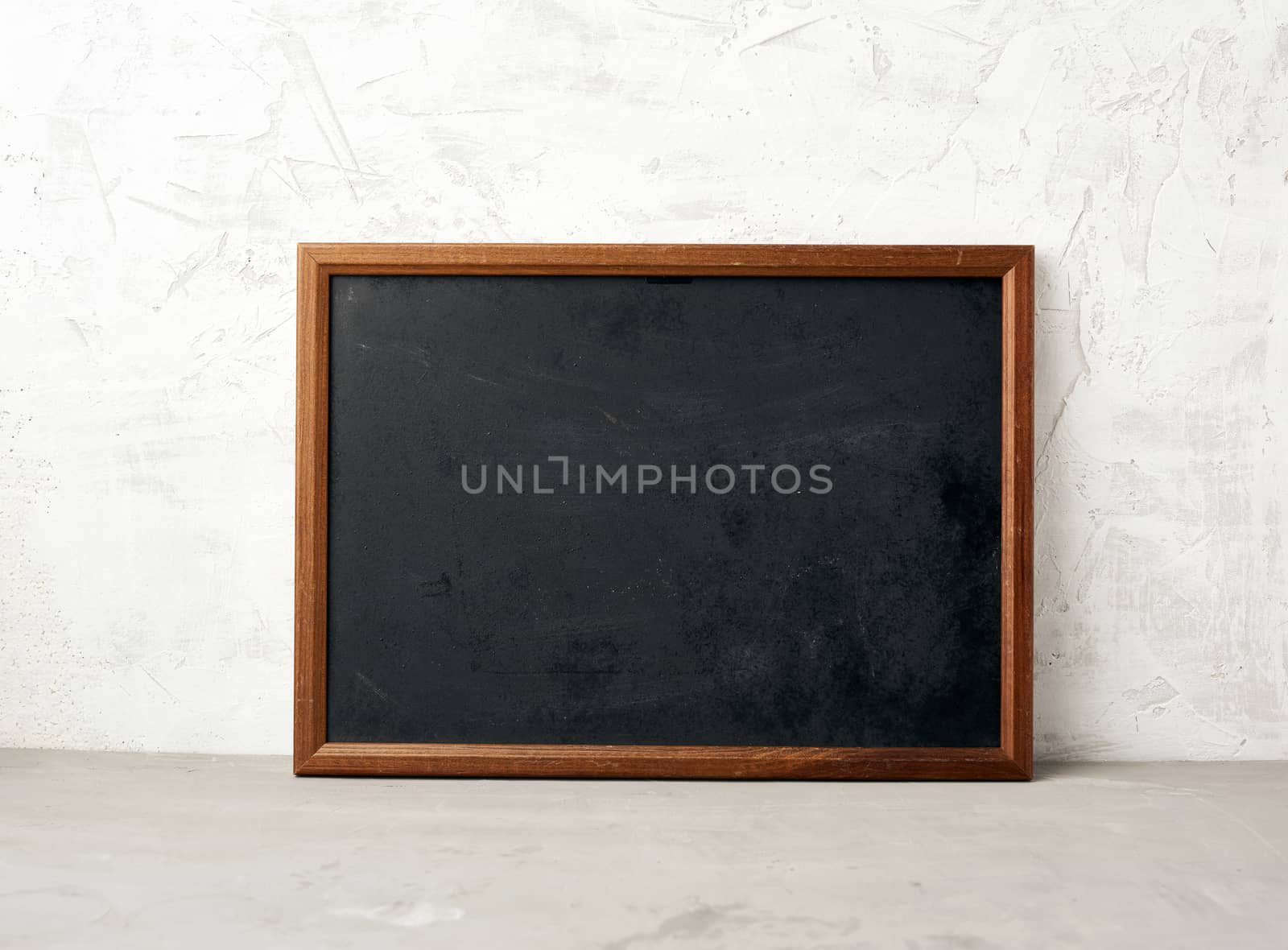 empty wooden rectangular frame, chalk board for writing a to-do list, menu on a white cement background. Back to school