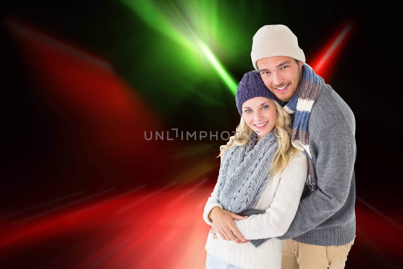 Attractive couple in winter fashion hugging against cool nightlife lights
