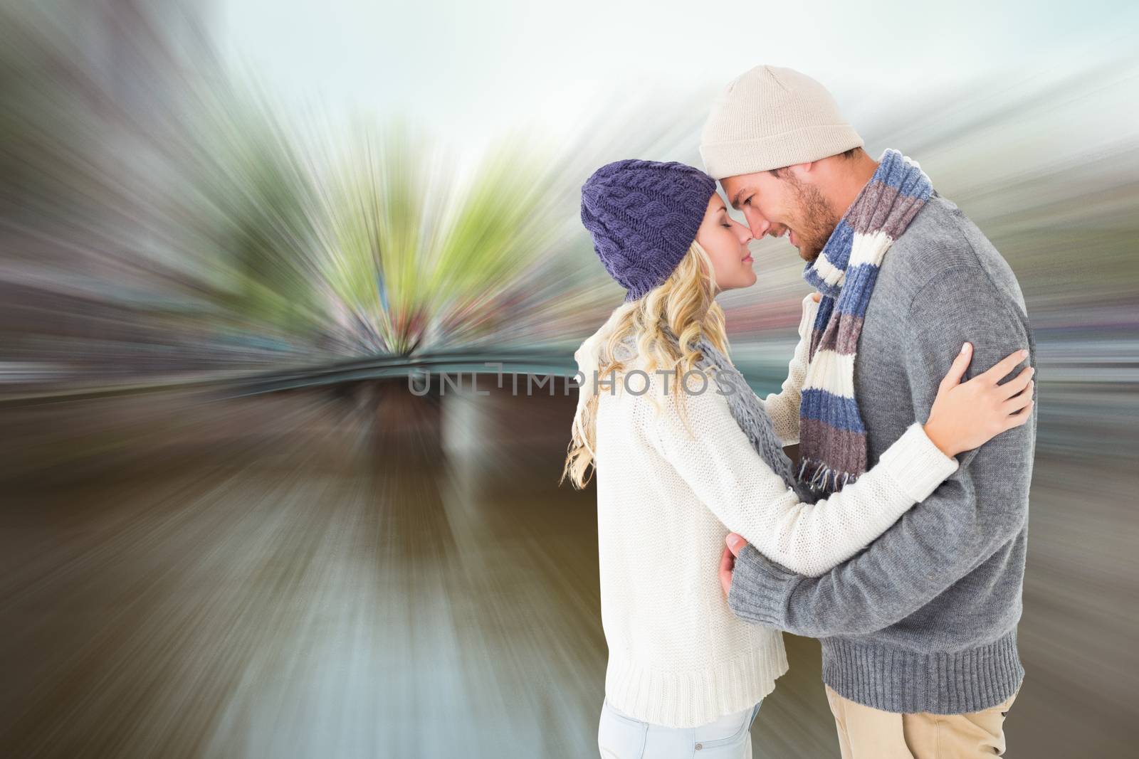Attractive couple in winter fashion hugging against canal in amsterdam
