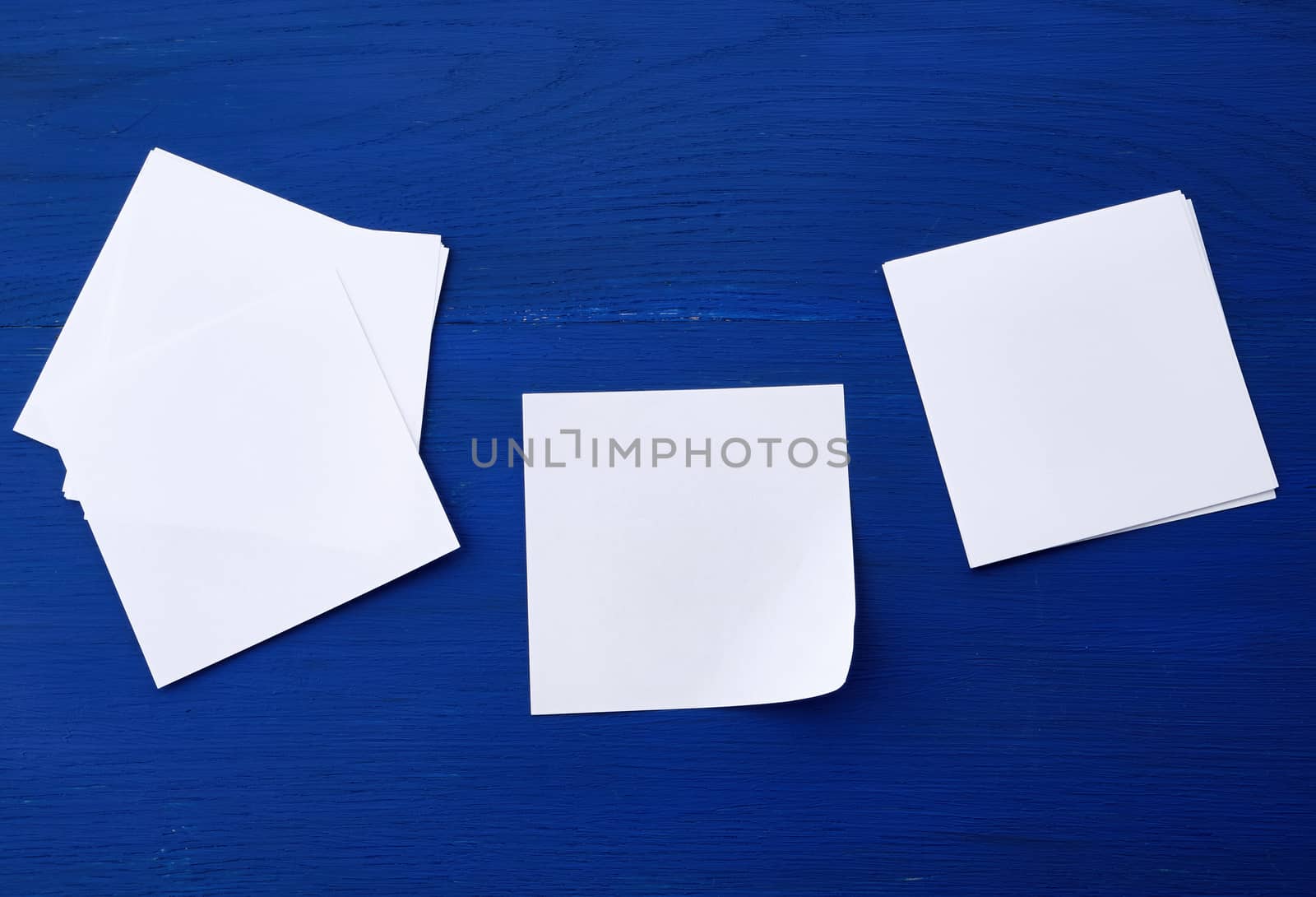 empty white sheet of paper on a blue wooden background, copy space