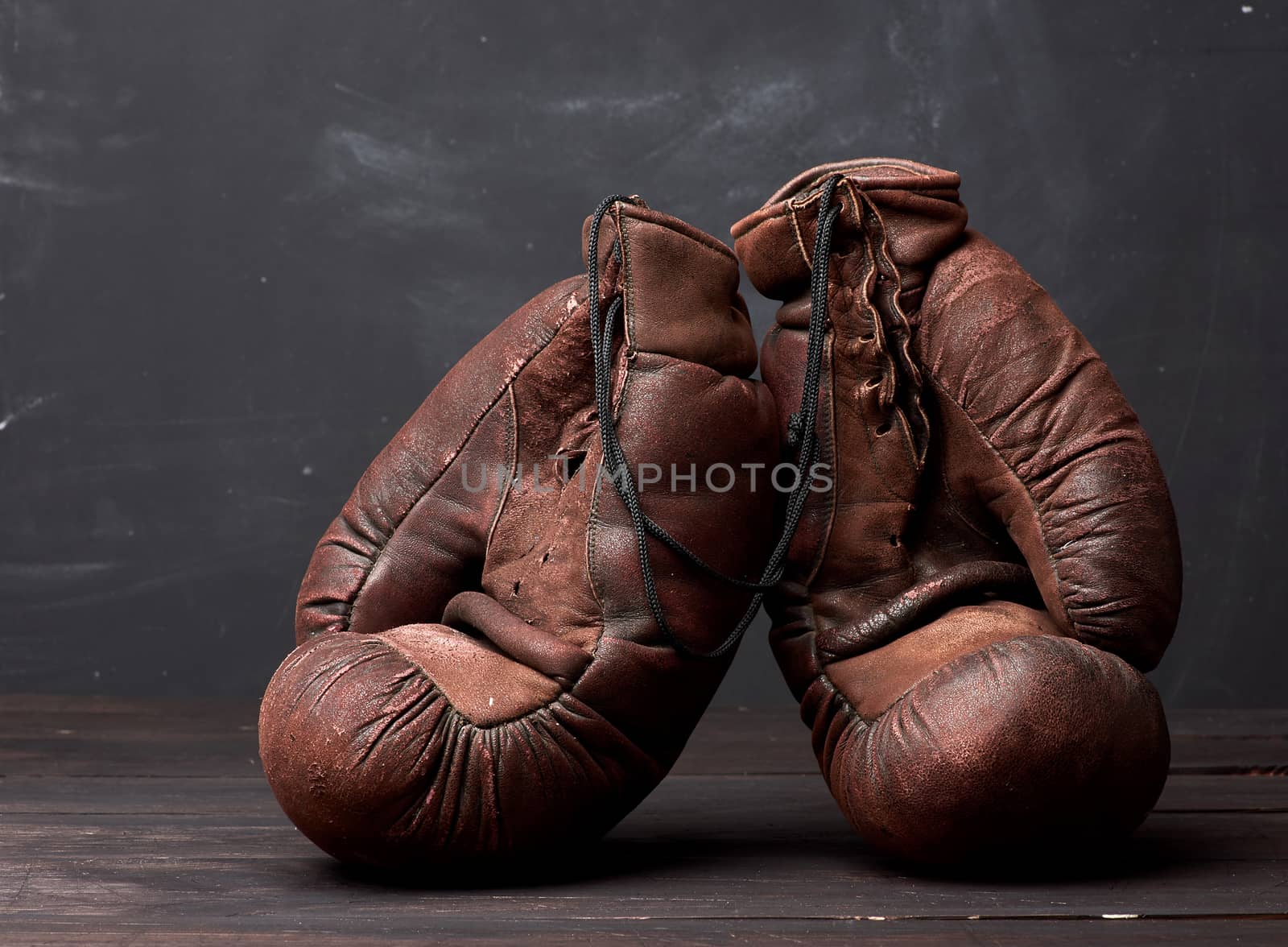 brown leather vintage boxing gloves on a black background, sports equipment