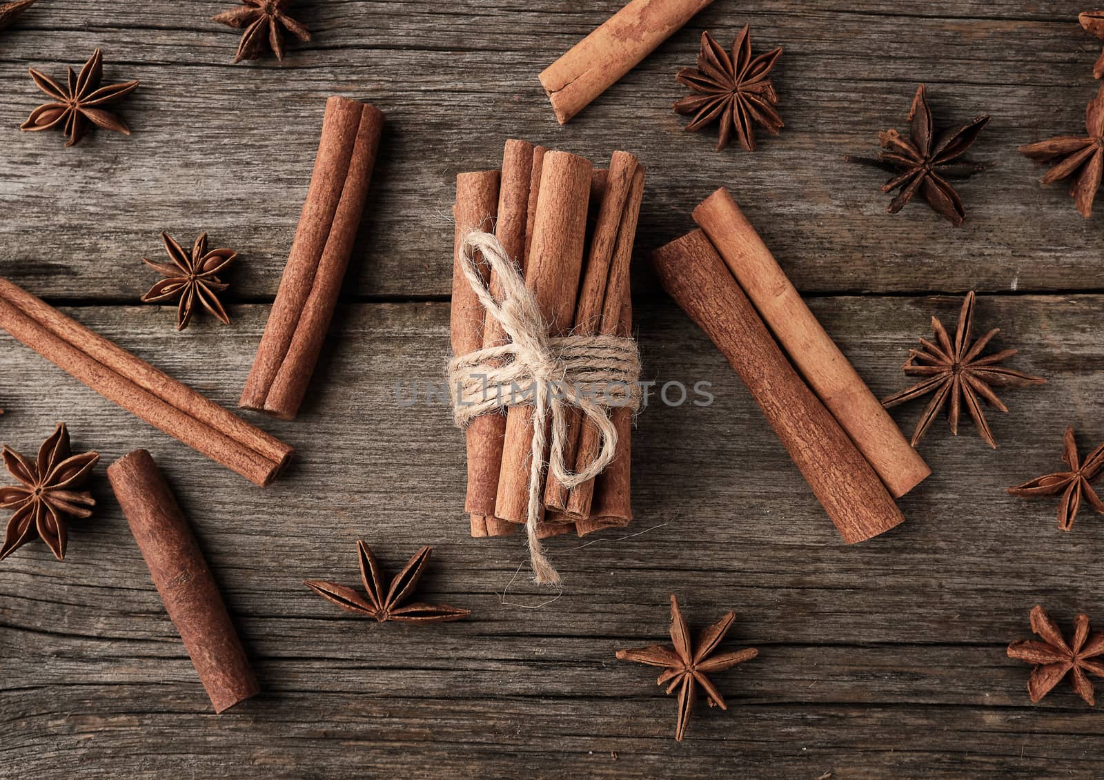 brown cinnamon sticks tied in a bun on a gray wooden background, tasty and fragrant spice, top view
