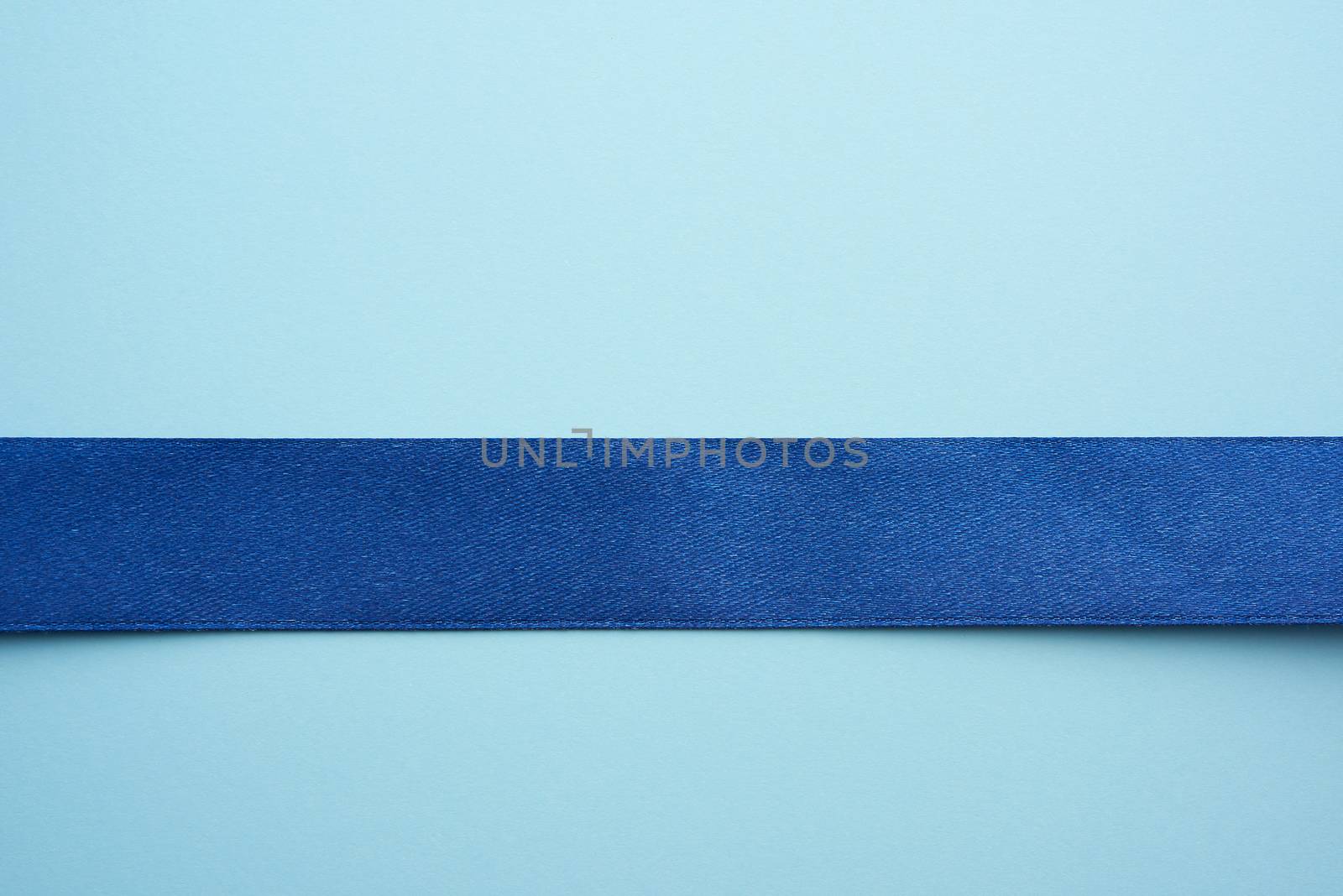 blue silk ribbon on a blue background, festive backdrop, place for text