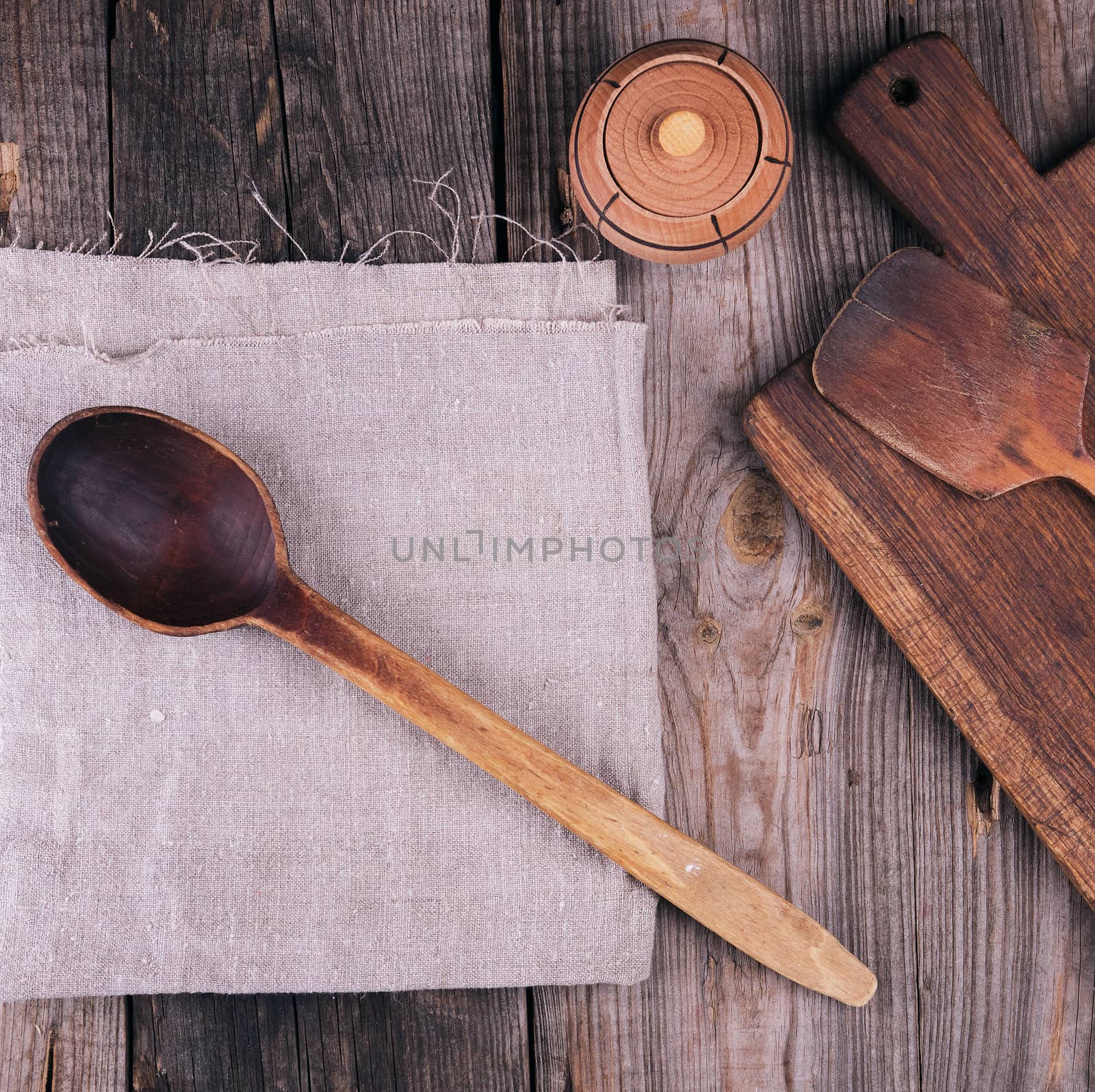 very old empty wooden spoon and rectangular cutting board, top view, gray wooden background 