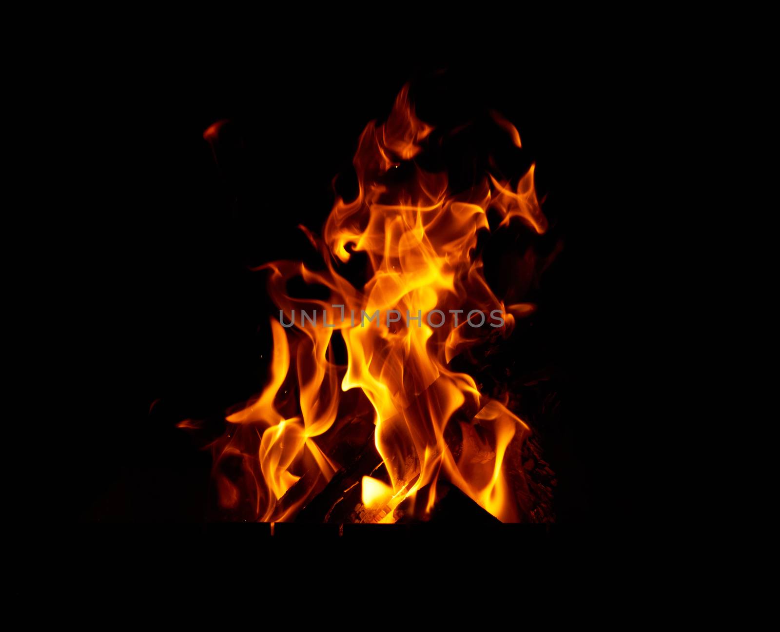 burning wooden logs in a bonfire at night, orange flames