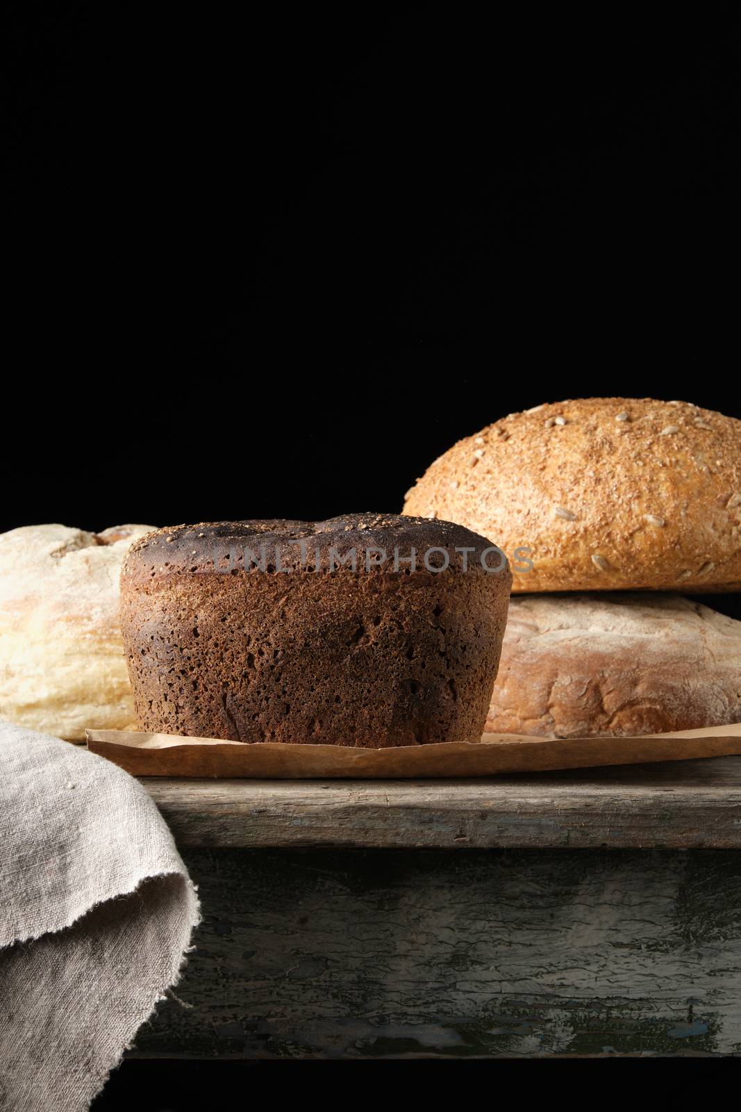 baked rye flour bread on a wooden table, dark background