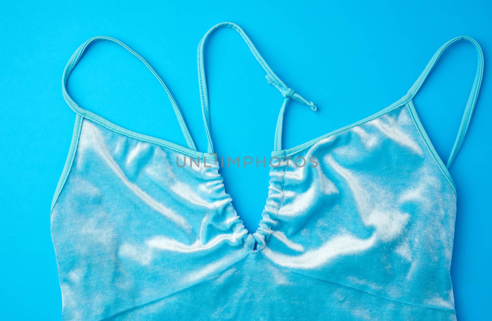 blue velour top on a blue background, female wardrobe detail, top view