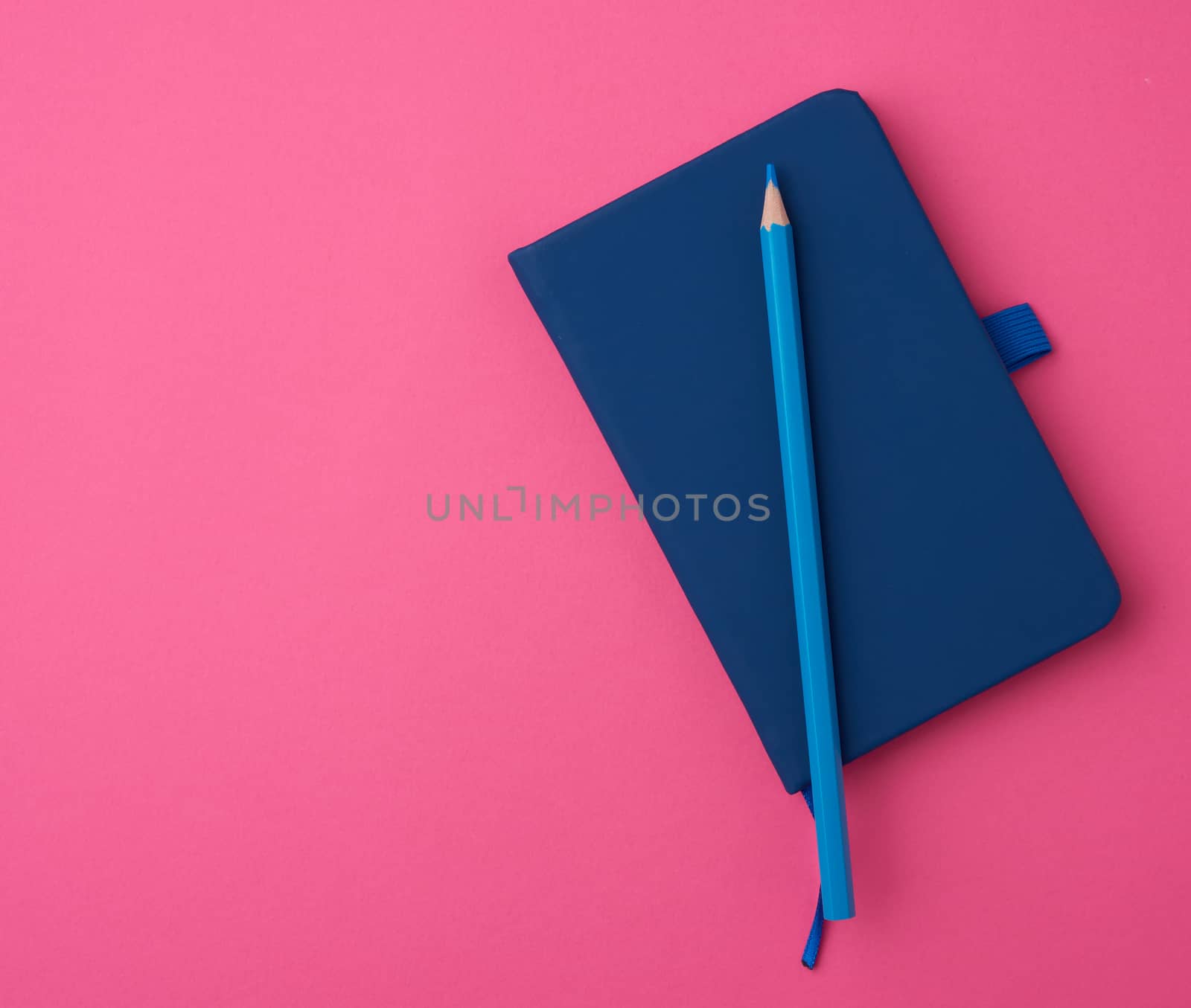 blue notebook on a pink background, backdrop for the designer