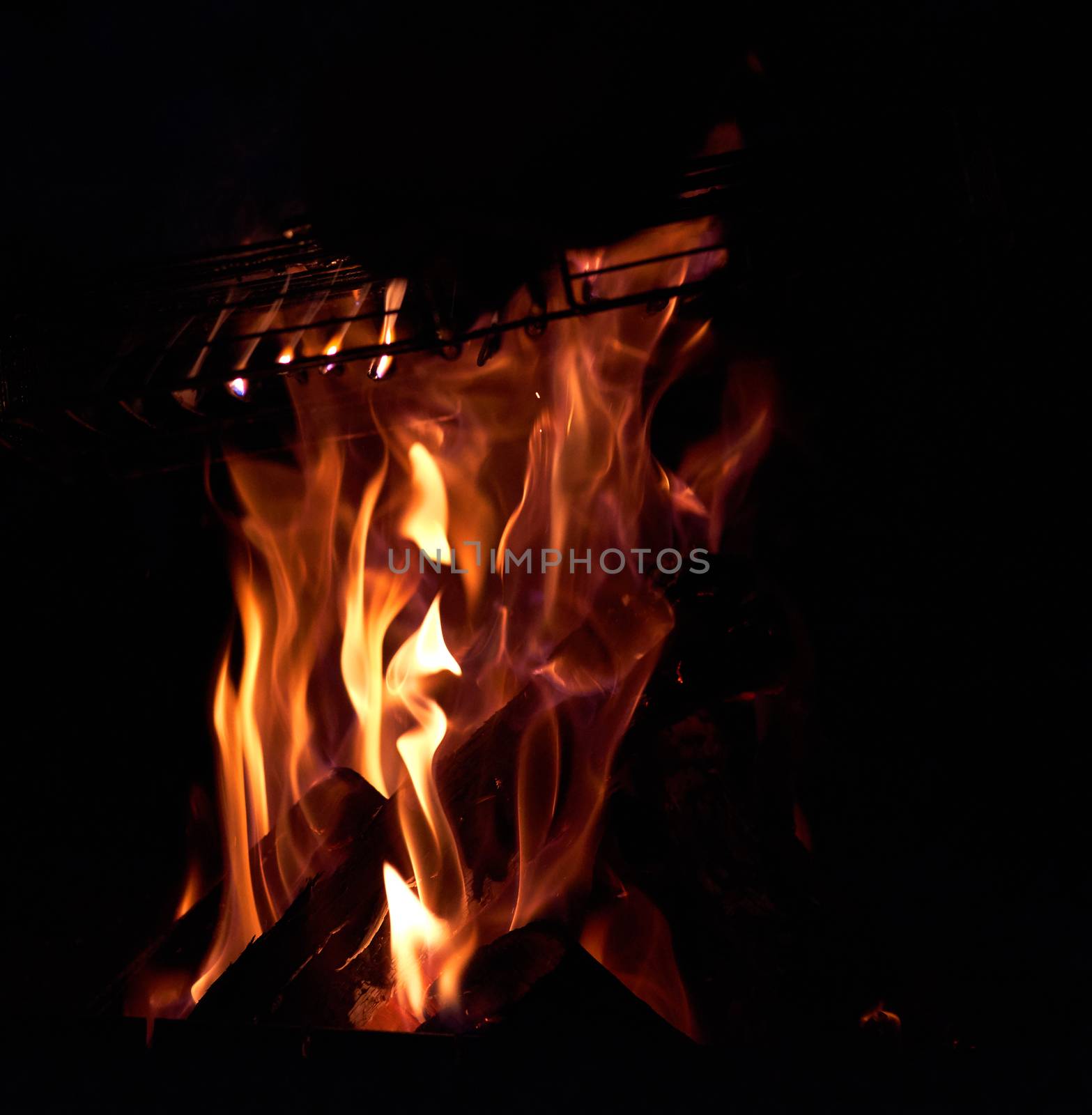 burning wooden logs in a bonfire at night by ndanko